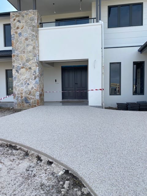 Premium aggregate driveway with natural stone column entrance